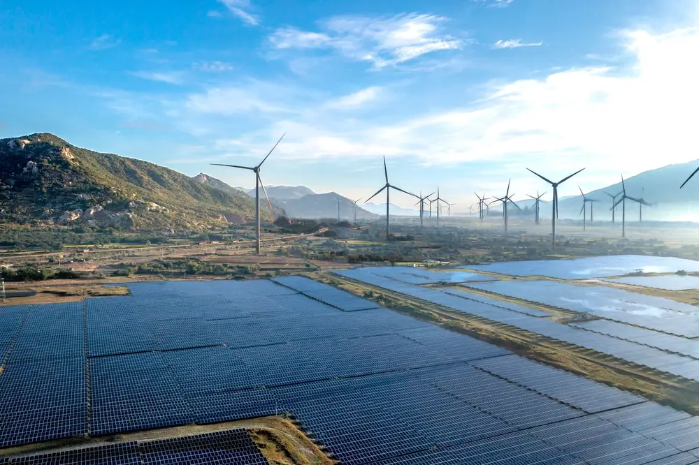 Aerial view of a wind farm beside solar panel arrays