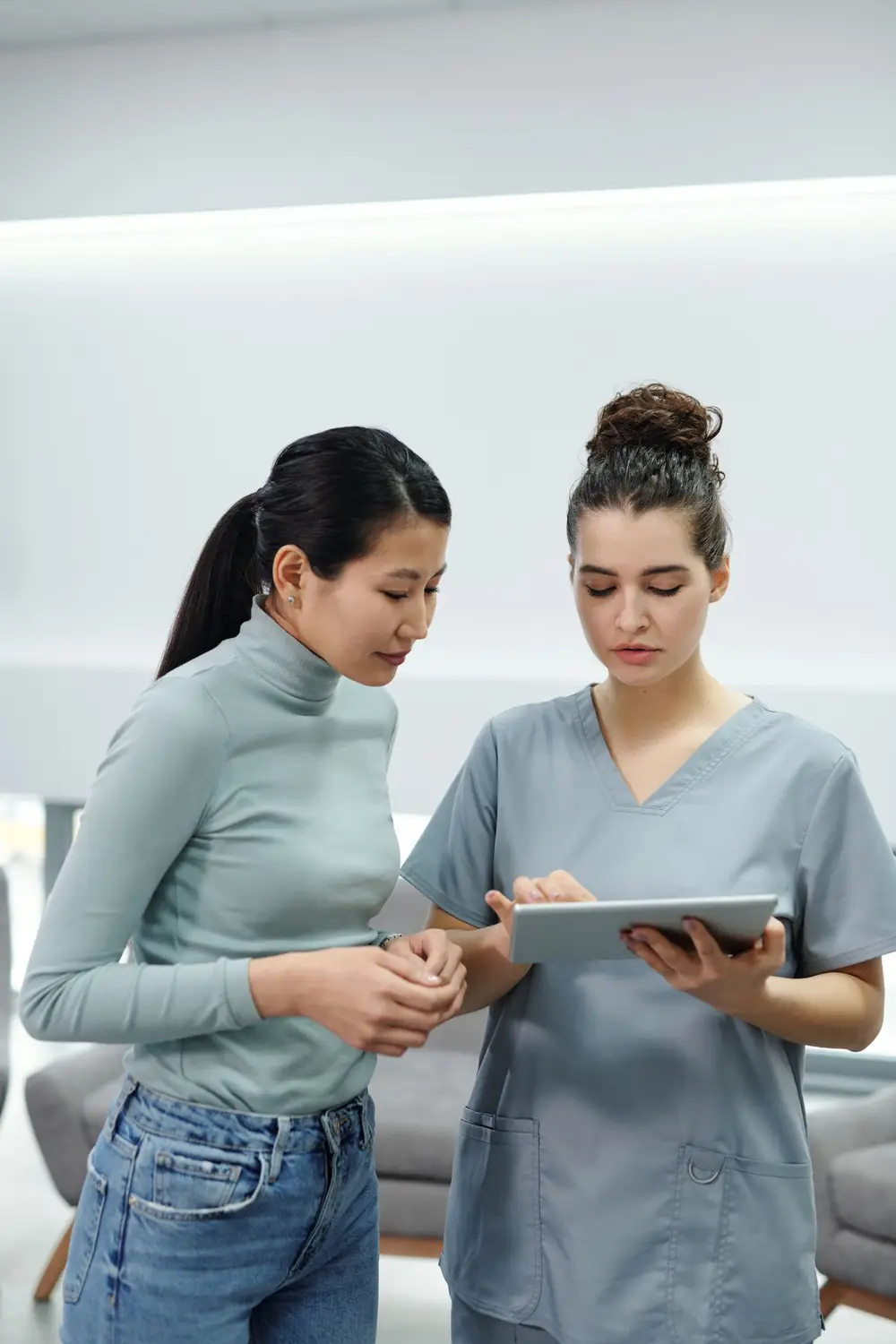A clinician showing test results to a patient on a tablet